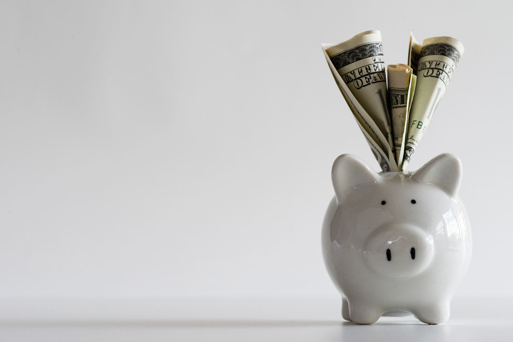piggy bank with cash sticking out of it